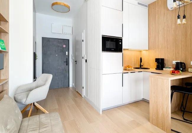 Balkon apartamentu z wygodnymi fotelami i widokiem na las, góry oraz piękne konie nieopodal.